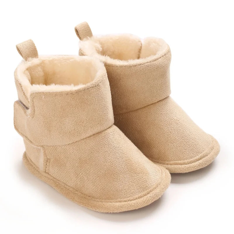 Beige baby boots with fluffy cream lining, wide ankle cuffs, and pull loops at the back.