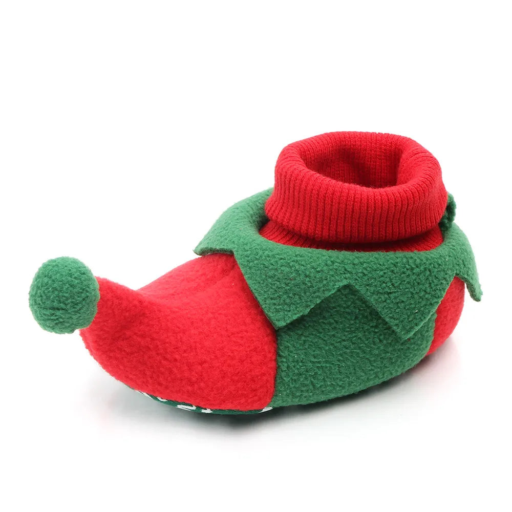 Red-and-green elf baby bootie with a folded red cuff, pointed trim, and a green pom-pom at the toe.