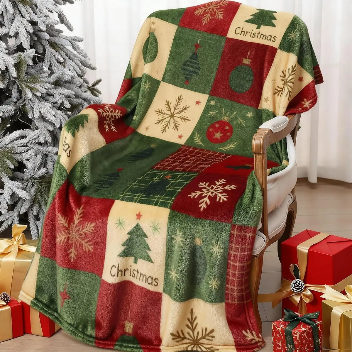 Red, green, and cream patchwork-print throw blanket with Christmas trees, ornaments, and snowflakes, draped over an armchair.