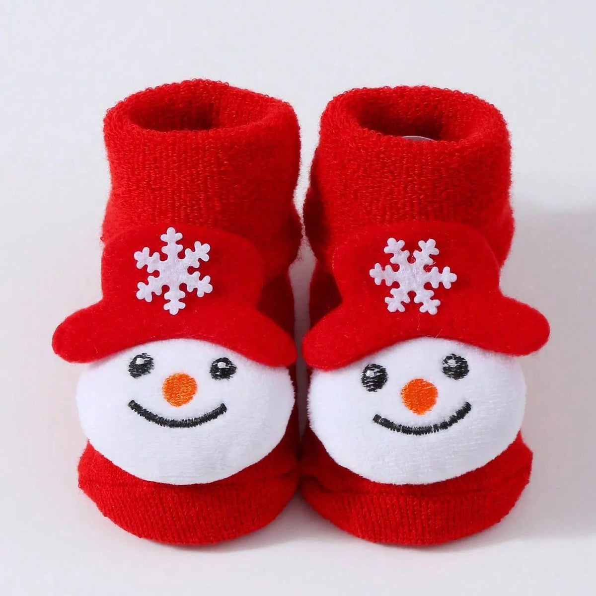 Red cuffed baby socks with smiling snowman faces and red hats decorated with white snowflakes.