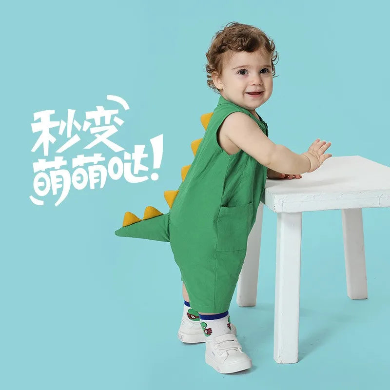 Baby standing in green dinosaur tail romper costume