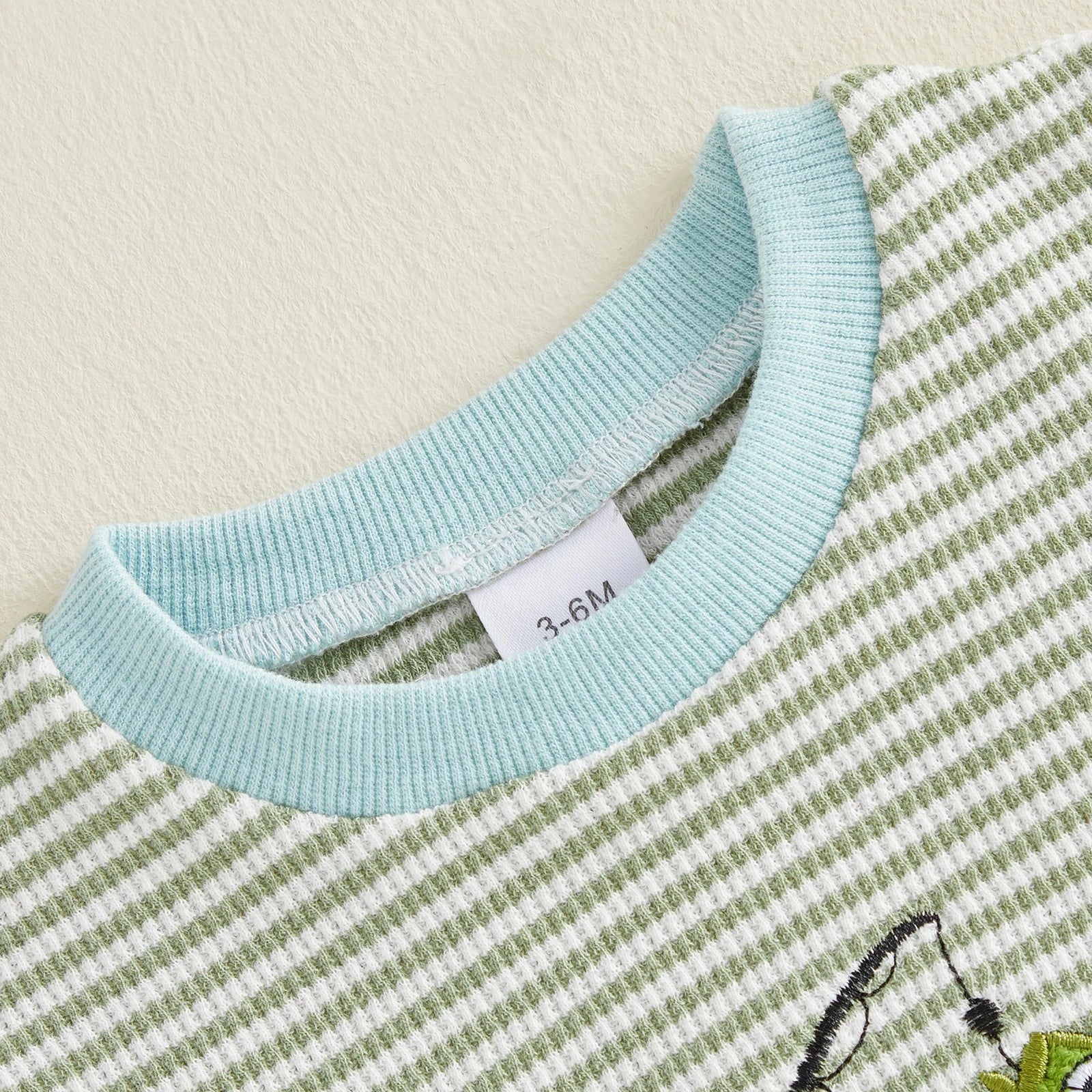 Close-up of fish embroidery detail on baby romper