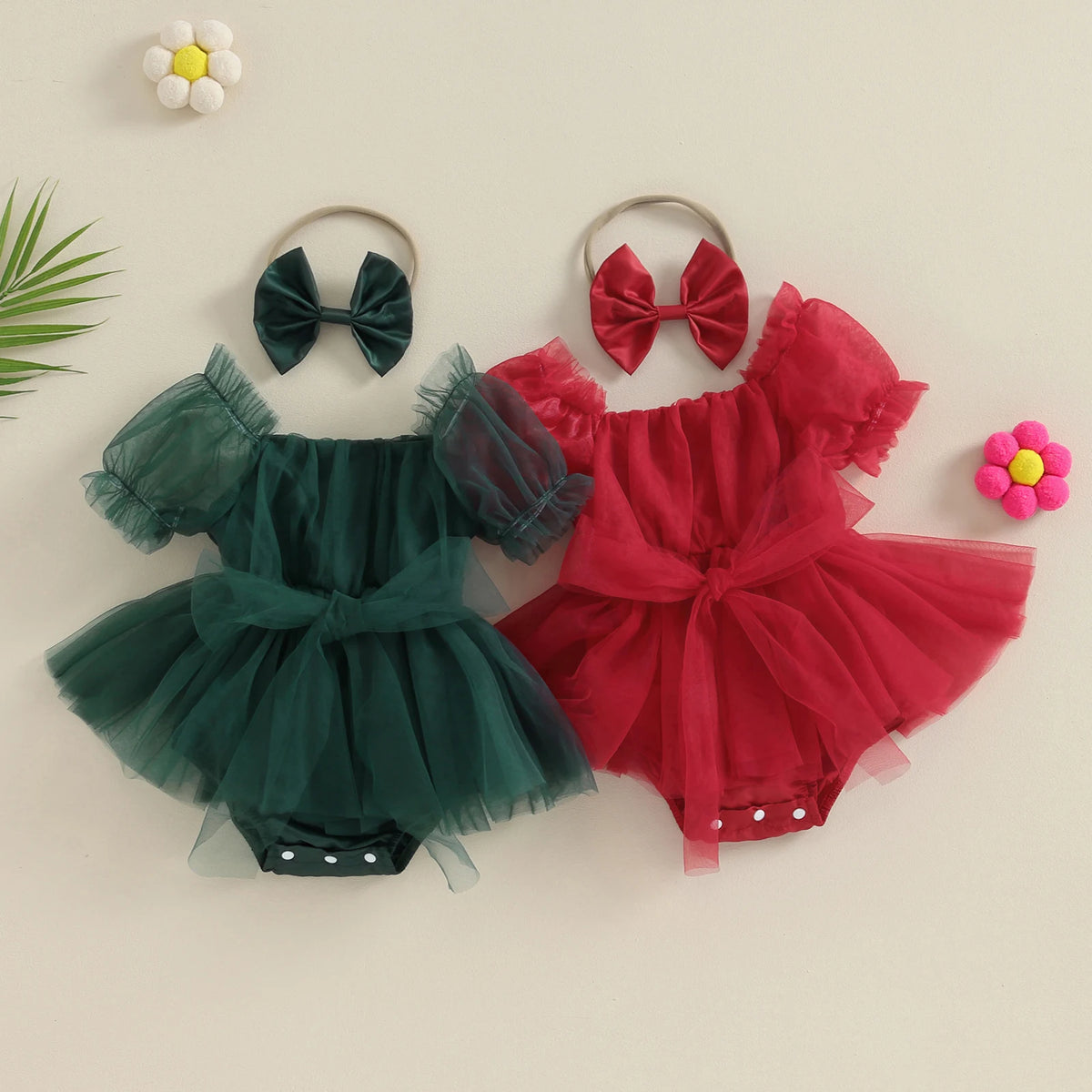 Green and red baby romper dresses with sheer puff sleeves, gathered skirts, waist bows, and coordinating bow headbands.
