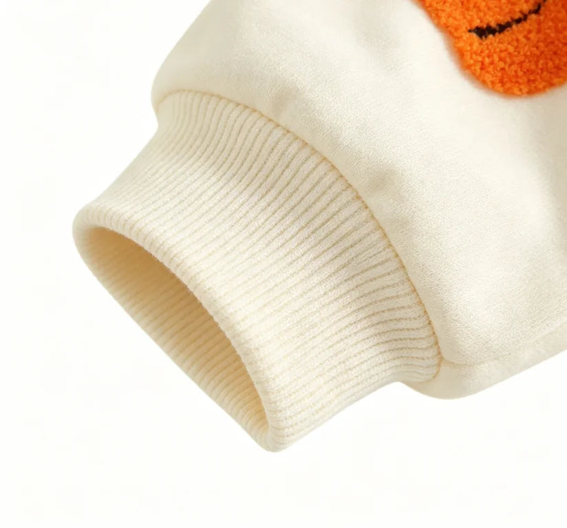 Close-up of ribbed cuff on sleeve of beige infant bodysuit