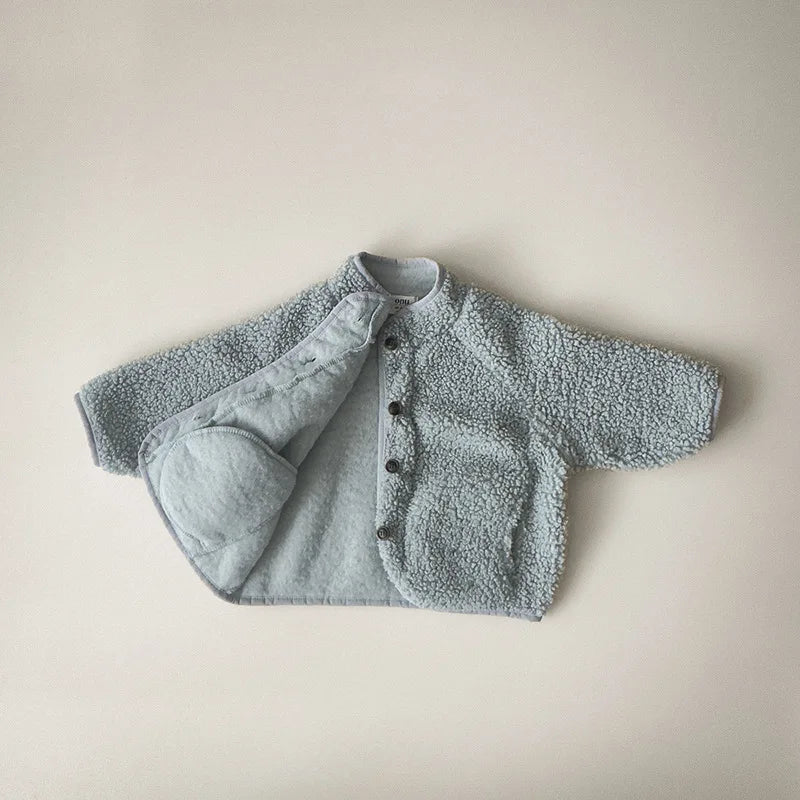 Children's winter coat displayed on hanger in white color