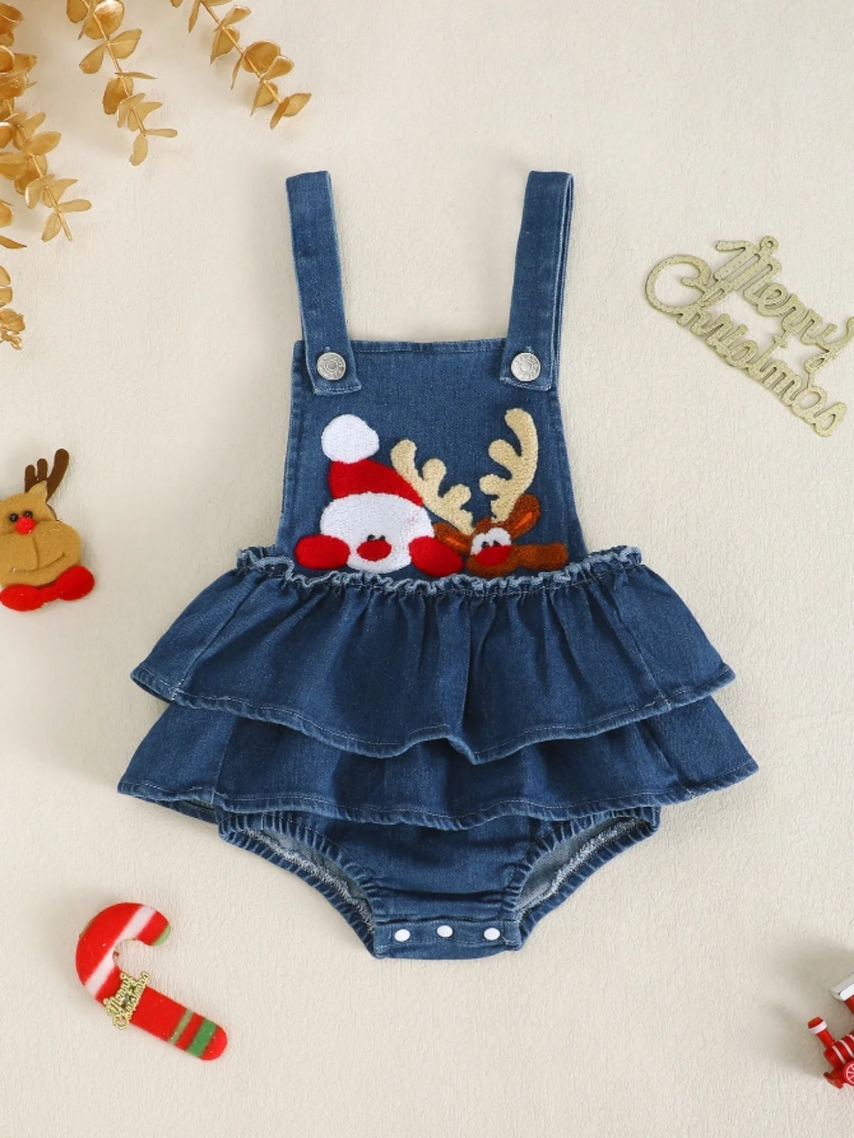 Blue denim-style baby romper with buttoned shoulder straps, tiered ruffles, and Santa and reindeer appliques.
