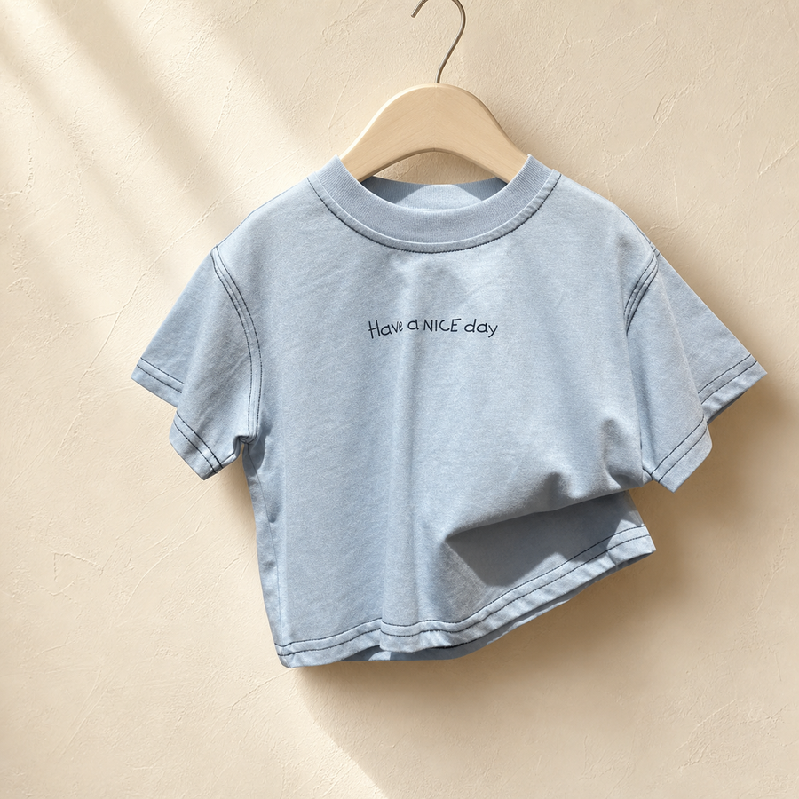 Close-up of Blue Have a Nice Day Short Sleeve Tee on a wood hanger