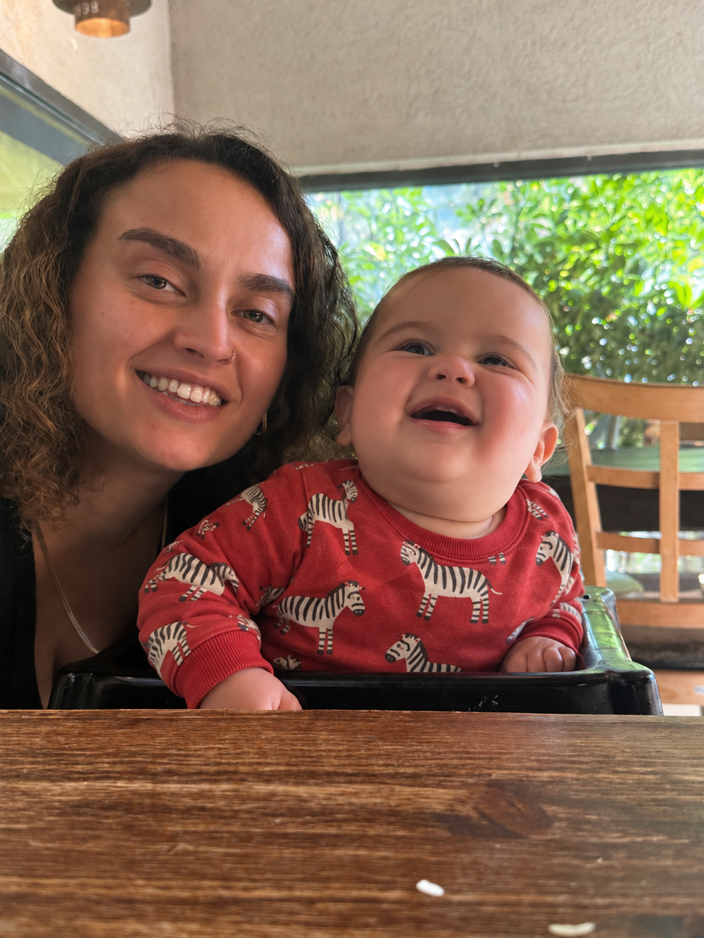 Orel with her baby wearing a red zebra sweatshirt